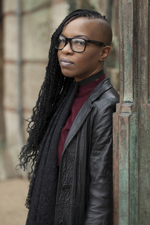 Woman with Glasses and Leather Coat Looking at Cameraの写真素材