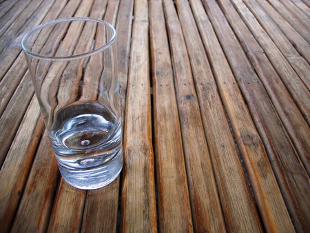 Near empty glass on a wood table top made from listelの写真素材