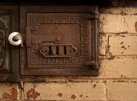 Antique brick oven detail. Paint is falling off, metal is rusted