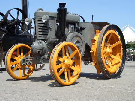 Older yellow grey tractor on display in farming expoの写真素材