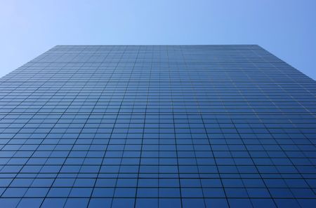 Skyscraper seen from below, a glass wall going up to the skyの写真素材