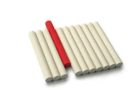 Red chalk standing out from a row of white onesの写真素材