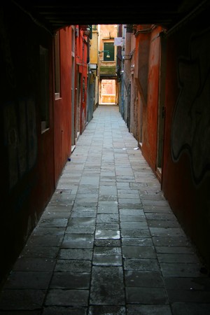 Small backstreet in Venice enclosed by colored buildingsの写真素材