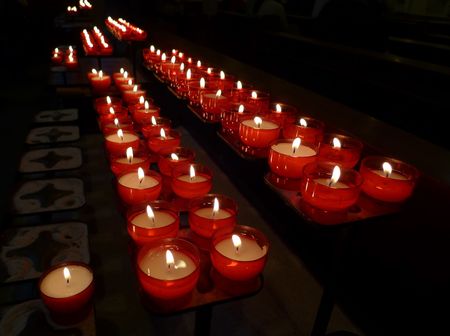 Devotional candles flaming in the dark of a churchの写真素材