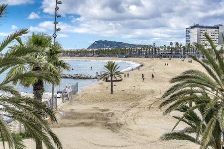 The beach of Barcelona with palm trees and yachts. Barcelona, Spain - May 13, 2018.のeditorial素材