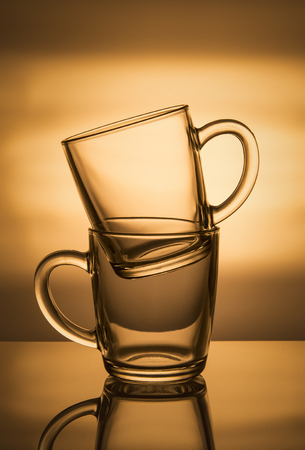 Two glass cups on an orange background.の写真素材
