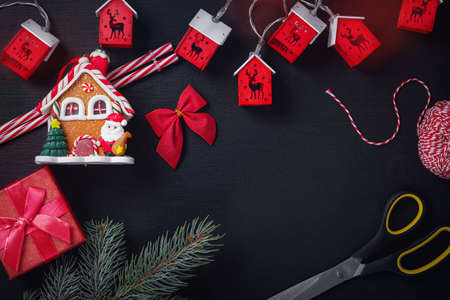 Beautiful christmas decor baubles and scissors on dark black background. Flat lay design. Copy Space. Horizontal.の写真素材