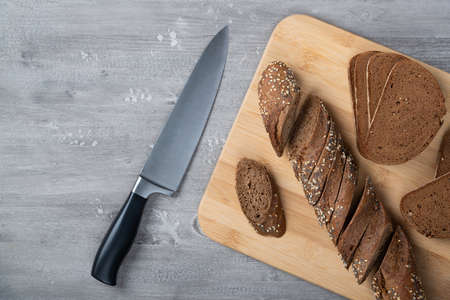 Rye bread and a knife on a cutting board.の写真素材