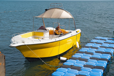 A yellow yacht at the pier at anchor