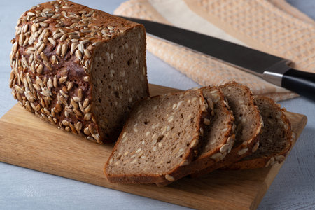Sliced rye bread on cutting board. Whole grain rye bread with seeds