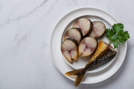 Headless mackerel, pieces of mackerel in a plate on a white table. Top viewの写真素材