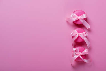 Pink macaroons on pink background. Sweet background. Flat lay, top view, copy spaceの写真素材