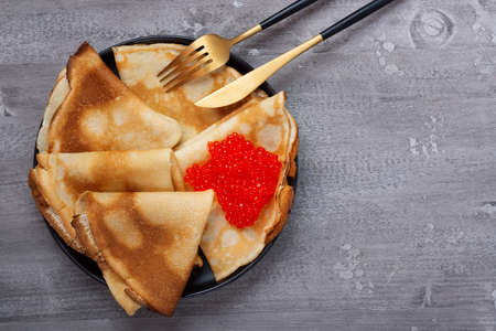 Russian pancakes with red caviar on a grey tableの写真素材