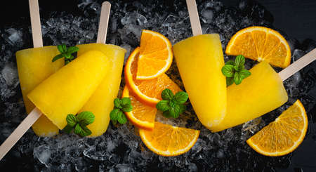 Fruit orange ice lolly and slices of orangeの写真素材