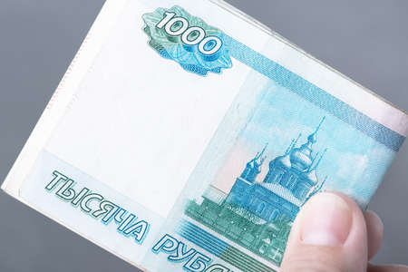 Hand with Russian rubles on a grey background, bills one thousand rublesの写真素材