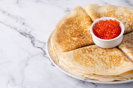 Pancakes with red caviar on a marble table, with copy space for text.の写真素材