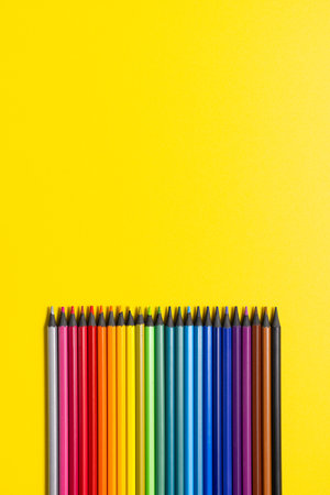 Set of multi-colored pencils on a yellow background.の写真素材