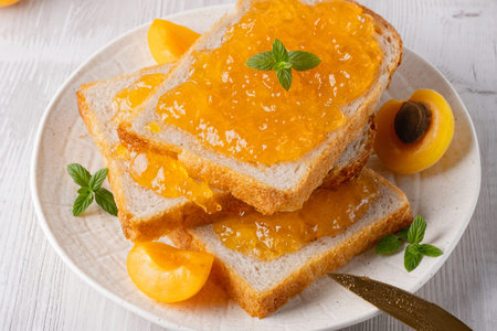 Toasts with tasty apricot jam on a white wooden tableの写真素材
