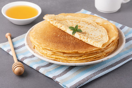 Stack of traditional russian pancakes blini on gray background with copy space. Homemade russian...