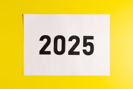 White sheet of paper with the inscription 2025 on a yellow background.