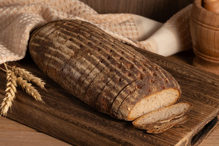 Multi grain sourdough bread with flax seeds cut on a wooden board, closeup view. Healthy vegan bread...