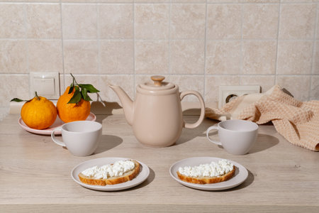 Breakfast scene featuring two plates wiCozy Breakfast Setup with Tea and Fresh Toastの写真素材