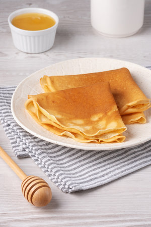 Traditional Russian pancakes with honey on a white wooden tableの写真素材