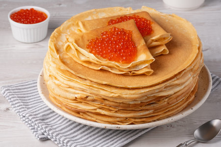 Freshly baked pancakes with red caviar