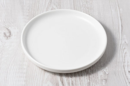 Empty plate on white wooden table