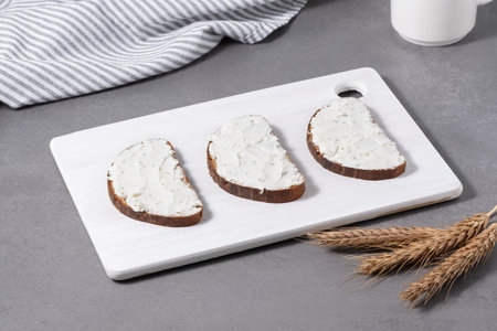 Sandwiches with cream cheese on a white cutting board