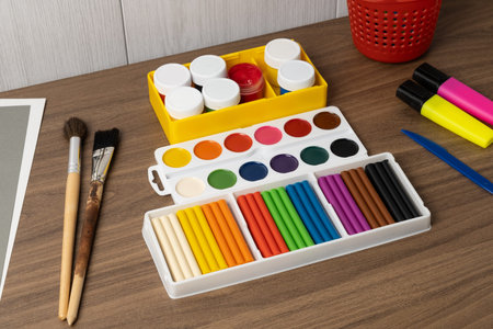 Craft supplies are arranged on a table with paint, markers, and brushes ready for creative projects...