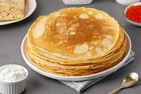 Freshly baked pancakes with sour cream and red caviar.の写真素材