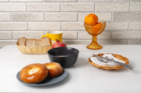 Breakfast table with baked goods, fruit, and drinks set in a simple kitchen environmentの写真素材