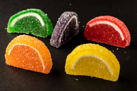 close-up black background mixed color fruit flavored sweet soft candyの写真素材