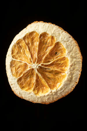 close-up of dried round orange slice on a black backgroundの写真素材