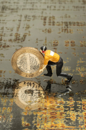 financial economy concept with miniature human figures and coins