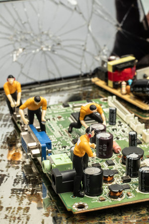 industry concept with miniature human figures working in electronics repair and manufacturingの写真素材