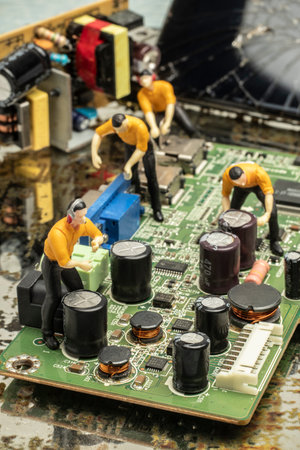 industry concept with miniature human figures working in electronics repair and manufacturing