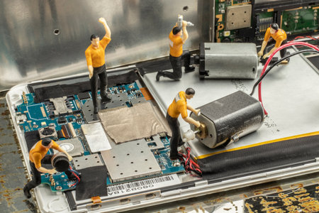 industry concept with miniature human figures working in electrical and electronic repair and productionの写真素材