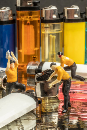 Industry concept with miniature human figures working in gas lighter repair and productionの写真素材