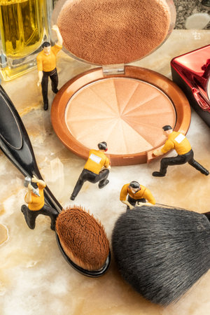 cosmetics concept with miniature human figures working on makeup