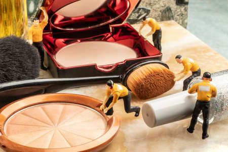 cosmetics concept with miniature human figures working on makeupの写真素材