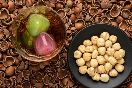 close-up fresh delicious peeled hazelnuts in black plate background also hazelnut shells high...