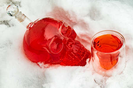 close-up white background snow full of high alcohol whiskey clear glass decanter decanter skull shot glass alcohol setの写真素材