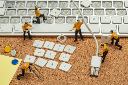 new year 2023 creative concept with close-up small miniature working men and office equipment computer keyboard keysの写真素材