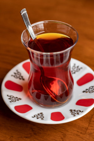 close-up detail traditional treat hot delicious flavored infused turkish tea in thin glass cup in patterned plateの写真素材