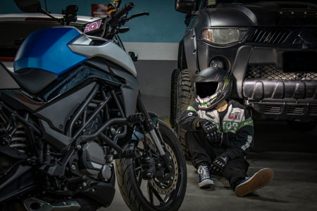 concept of motorcycle and helmeted driver with gloves inside indoor garage