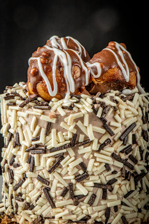Close-up single-person cake with chocolate inside and profiteroles on top