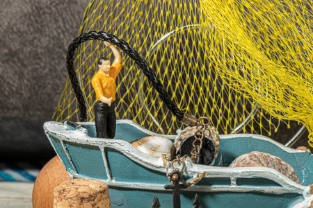 close-up detail miniature human figures lighthouse fishing boat designed with beach fishing concept...