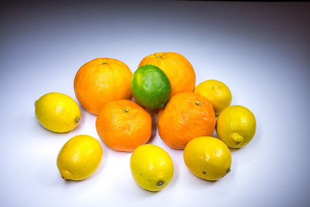 Citrus compositon with oranges, tangerines, lemons and lime painted with lightの写真素材